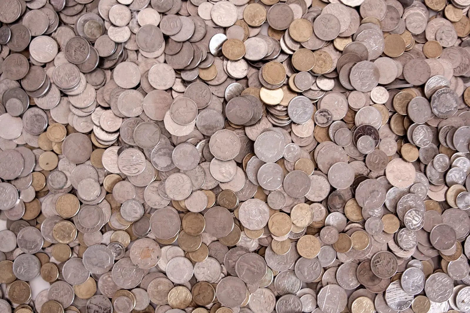 A dense pile of Australian coins in silver and gold tones.