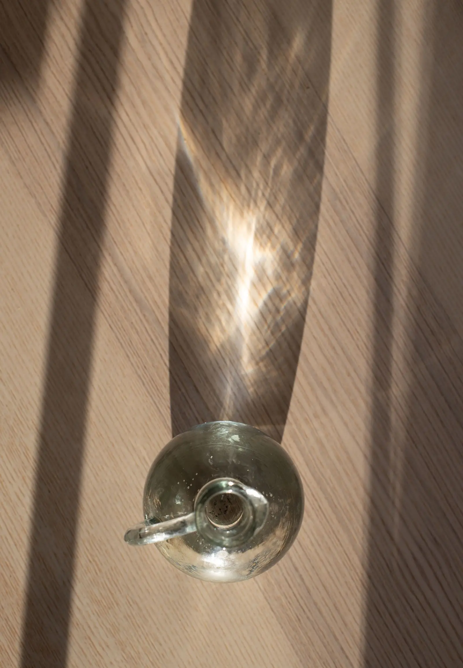 An empty cut-glass tumbler on a table catching warm late-afternoon light.